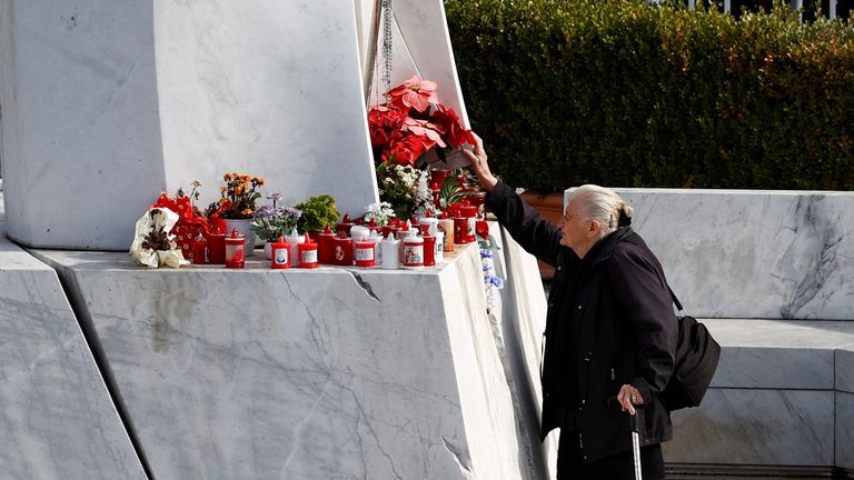 A woman touches a flower in front of a statue of the late Pope John Paul II outside the Gemelli Hospital where Pope Francis is hospitalised for bronchitis treatment in Rome, Italy, February 15, 2025. Pic: Reuters