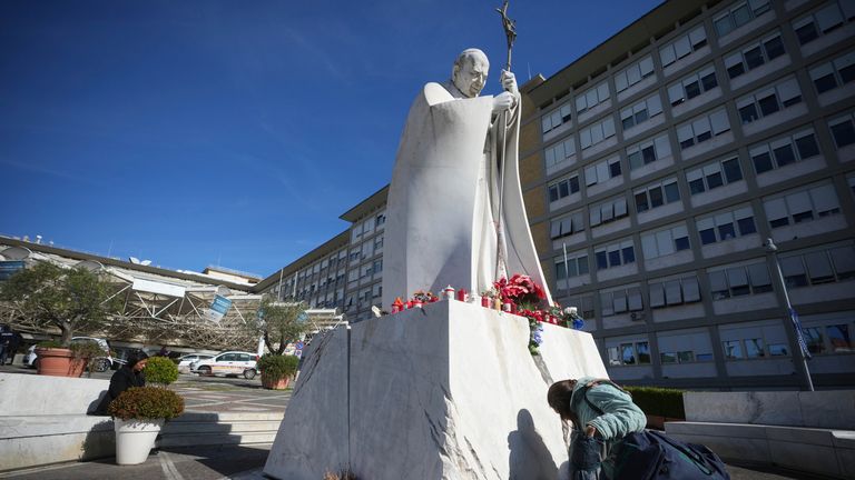 A woman kneels at the foot of a statue of late Pope John Paul II outside the Agostino Gemelli Polyclinic in where Pope Francis was hospitalised Friday after a week-long bout of bronchitis.
Pic: AP