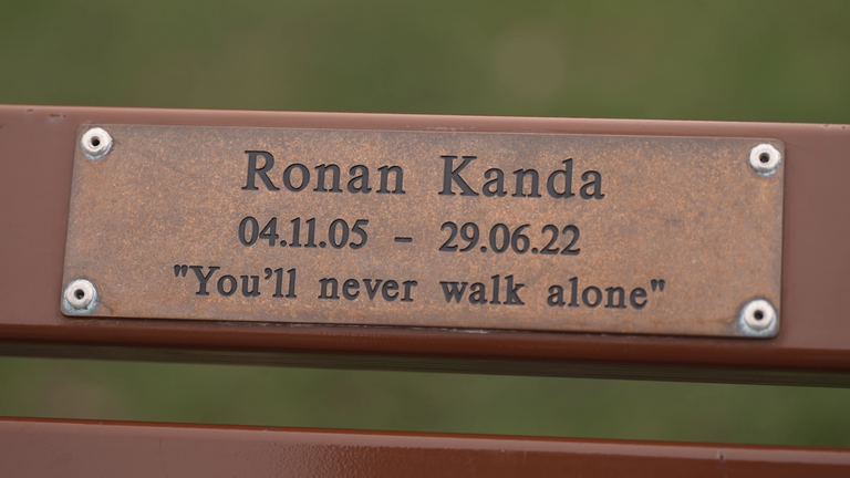 A memorial bench for Ronan with the phrase "You'll never walk alone" inscribed on it.