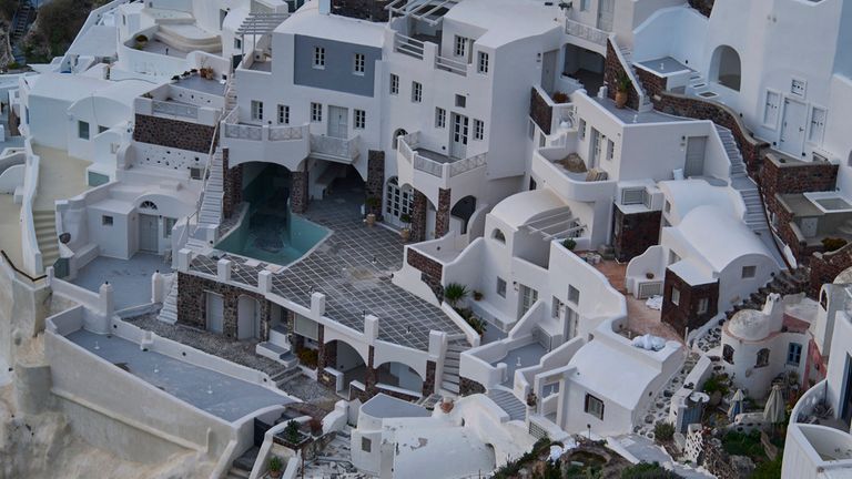 An empty swimming pool is seen in a group of clifftop buildings in the town of Oia on the earthquake-struck island of Santorini, Greece, Tuesday, Feb. 4, 2025. (AP Photo/Petros Giannakouris)