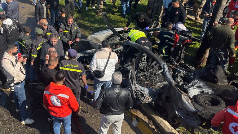 Civil defence workers and Lebanese soldiers gather next the remains of a burned car that was hit by an Israeli drone strike, in the southern port city of Sidon, Lebanon, Monday, Feb. 17, 2025.(AP Photo)