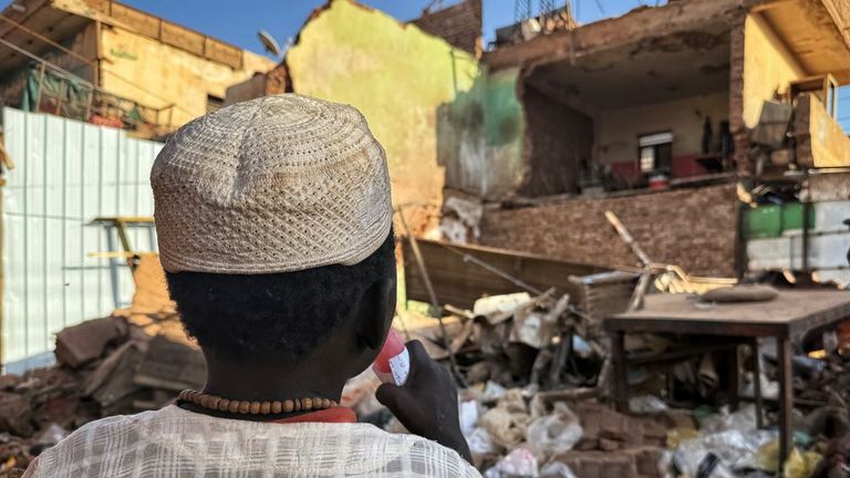 A child looking at a scene of destruction at a market in Sudan