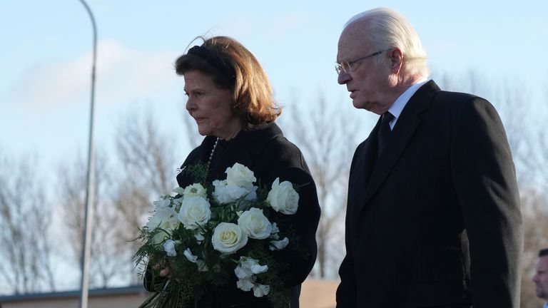 Sweden's King Carl XVI Gustaf and Queen Silvia arrive to place flowers at a memorial near the scene of a shooting on the outskirts of Orebro, Sweden