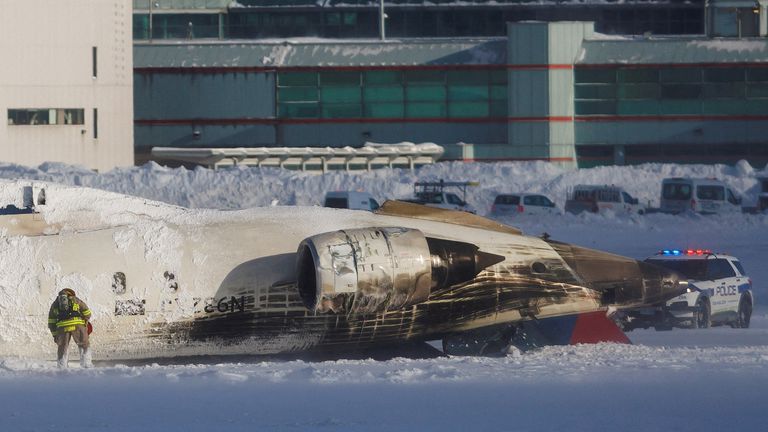 An emergency responder works around an aircraft on a runway, after a plane crash at Toronto Pearson International Airport in Mississauga, Ontario, Canada, February 17, 2025. REUTERS/Cole Burston REUTERS/Cole Burston