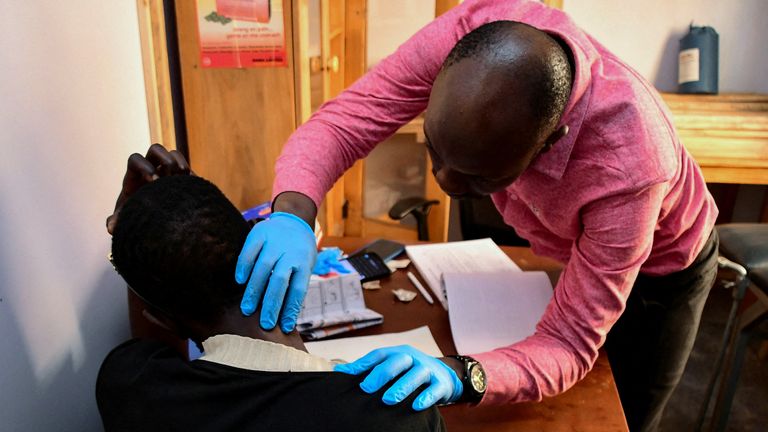 A medical clinic officer examines an unidentified transgender and LGBTQ member, who is one of their patients at the Ice Breakers Uganda (IBU) clinic in Makindye that supports HIV/AIDS programmes and treatment for the LGBTQ community in Salaama road, Kampala, Uganda June 1, 2023. REUTERS/Abubaker Lubowa/File Photo