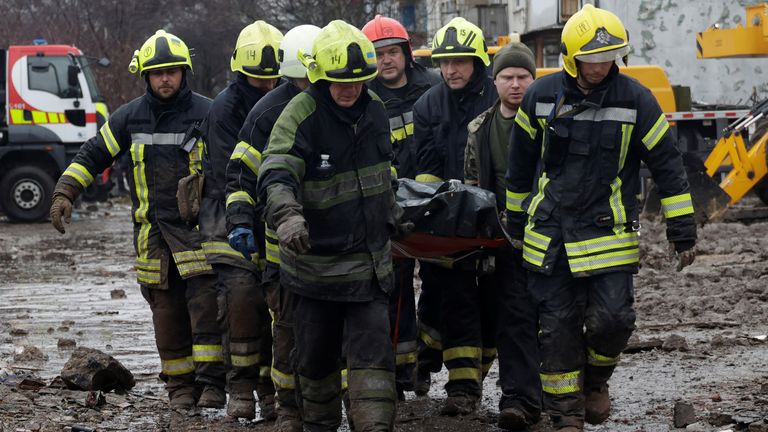 Rescuers carry the body of a person found under debris in Poltava.
Pic: Reuters/Sofiia Gatilova