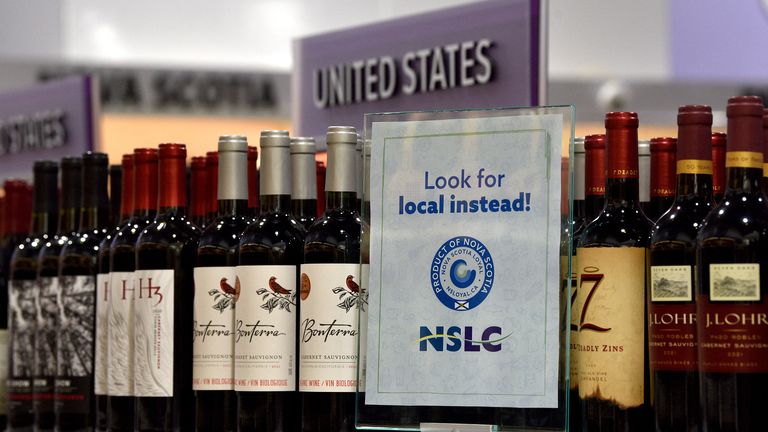 A sign encouraging Canadian shoppers to 'look for local instead' in front of US alcohol at a store in Halifax, Nova Scotia, after Donald Trump targeted Canada with tariffs. Pic: Reuters