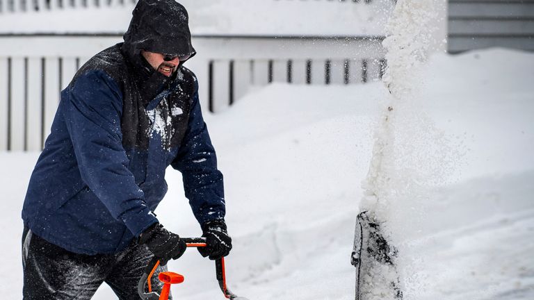 Chris Crowley struggles with heavy, wet snow Sunday afternoon, Feb. 16, 2025, as wind and driving sleet made conditions difficult to remove snow from a driveway on Shawmut Street in Lewiston, Maine. (Russ Dillingham/Sun Journal via AP)