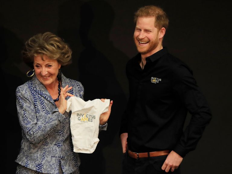 Princess Margriet of the Netherlands presents Britain's Prince Harry with an outfit for his newborn son at the launch of the 2020 Invictus Games, in The Hague, Netherlands, Thursday, May 9, 2019. Prince Harry returned to his royal duties Thursday after the birth of his son Archie Harrison, to launch the countdown for the fifth Invictus Games sports competition for injured service personnel and veterans. (AP Photo/Peter Dejong)