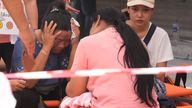 A woman cries as she waits for news as rescue work is under way. Pic: AP