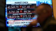 Financial news is displayed as people work on the floor at the New York Stock Exchange in New York, Tuesday, March 4, 2025. (AP Photo/Seth Wenig)