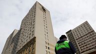 A traffic police officer stands next to a multi-storey residential building damaged in a recent Ukrainian drone attack, according to local authorities, in the course of Russia-Ukraine conflict, in Vidnoye, Moscow Region, Russia March 11, 2025. REUTERS/Stringer
