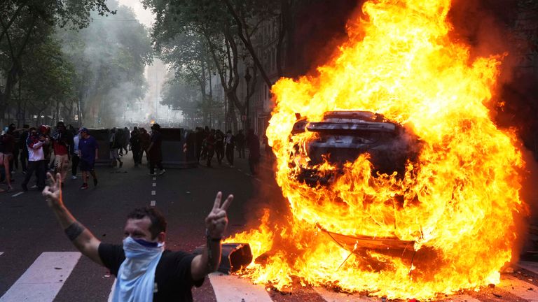 Protesters surround a burning car during a demonstration by soccer fans and retired people demanding higher pensions and opposing austerity measures implemented by Javier Milei's government in Buenos Aires. Pic: AP