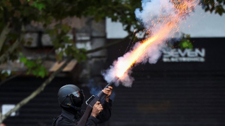 A police officer uses a crowd-control weapon, as football fans join the weekly protest of retirees against Argentinian President Javier Milei's adjustment policies, in Buenos Aires, Argentina March 12, 2025. REUTERS/Agustin Marcarian