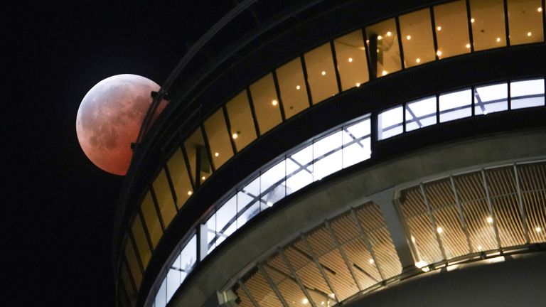 A full moon is seen behind the CN Tower during a "Blood Moon" lunar eclipse in Toronto, Ontario, Canada, March 14, 2025.  REUTERS/Arlyn McAdorey