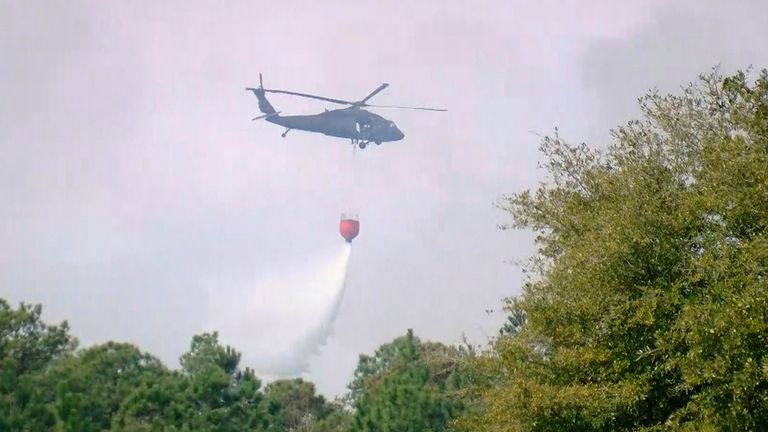 A helicopter drops water to help contain a fire in the Carolina Forest area. Pic: AP