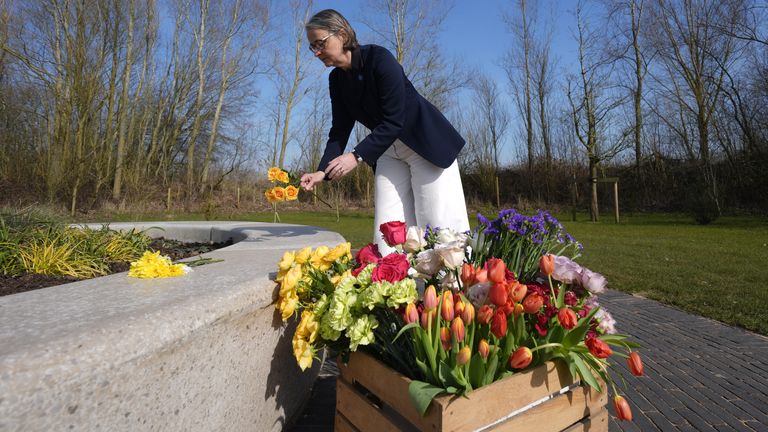 La directrice générale du National Memorial Arboretum, Philippa Rawlinson, jette des fleurs dans les arbres de la vie