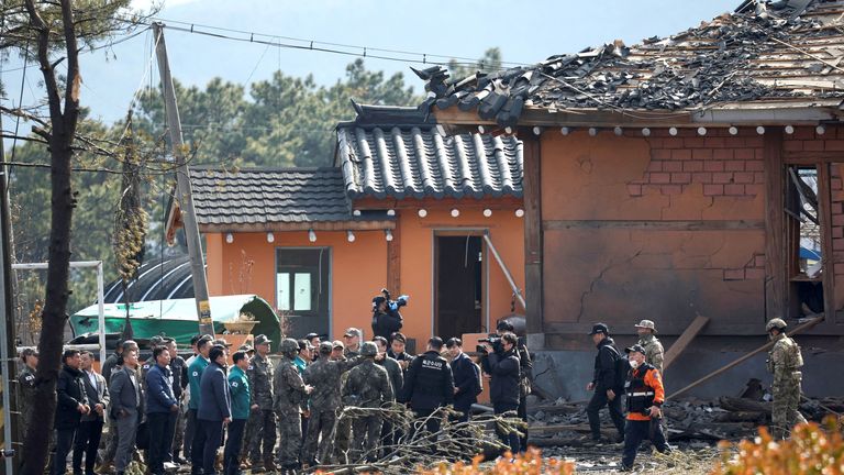 Officials examine near damaged buildings.
Pic: Reuters