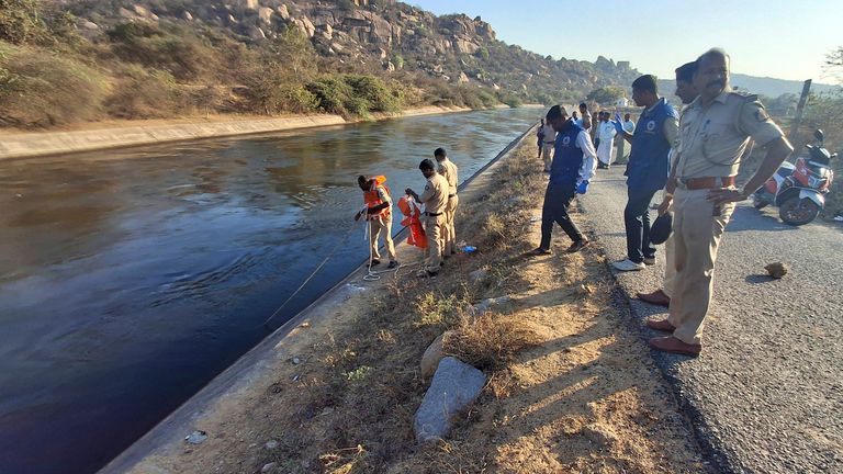 Police search for male travellers who were pushed into canal by three men in India. Pic: AP