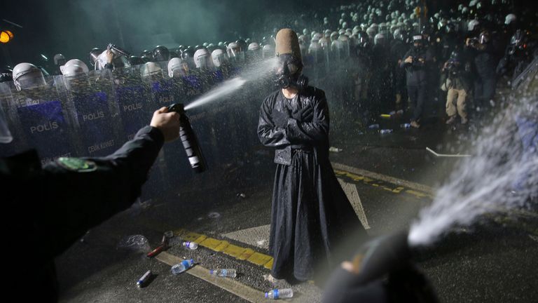 Riot police officers use pepper spray to clear a protester during a protest after Istanbul's Mayor Ekrem Imamoglu was arrested and sent to prison, in Istanbul, Turkey, Sunday, March 23, 2025. (AP Photo/Huseyin Aldemir)