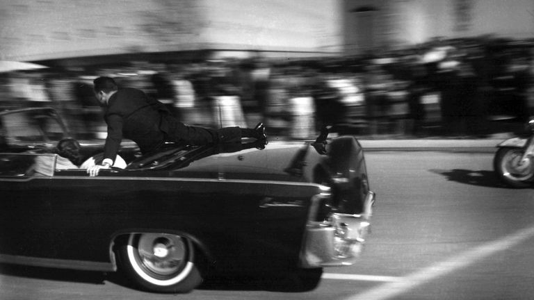 FILE - In this Nov. 22, 1963 file photo, the limousine carrying mortally wounded President John F. Kennedy races toward the hospital seconds after he was shot in Dallas. (AP Photo/Justin Newman, File)