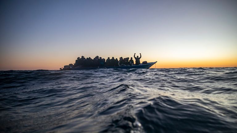 FILE - In this Feb. 12, 2021 file photo, migrants and refugees from various countries wait for assistance aboard an overcrowded wooden boat, as aid workers of the Spanish NGO Open Arms approach them in the Mediterranean Sea, international waters, at 122 miles off the Libyan coast. The United Nations' migration agency said Wednesday July 13, 2021, that at least 1,146 people died in the first six months of 2021, attempting to reach Europe on dangerous sea crossings, more than twice as many as in t