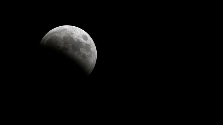 Total lunar eclipse covers half of the moon in the night sky on March 14, 2025 as seen from Parrish, Florida. (Mike Janes/Four Seam Images via AP Images)