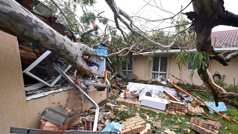 Debris lies at a damaged house by a fallen gum tree ahead of Tropical Cyclone Alfred&#39;s landfall, at Mudgeeraba on the Gold Coast, Australia.
Pic: AAP/Reuters