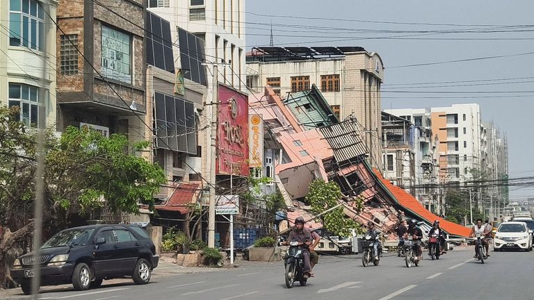 People ride motorcycles past a damaged building after a strong earthquake struck central Myanmar, in Mandalay, Myanmar, March 28, 2025. REUTERS/Stringer