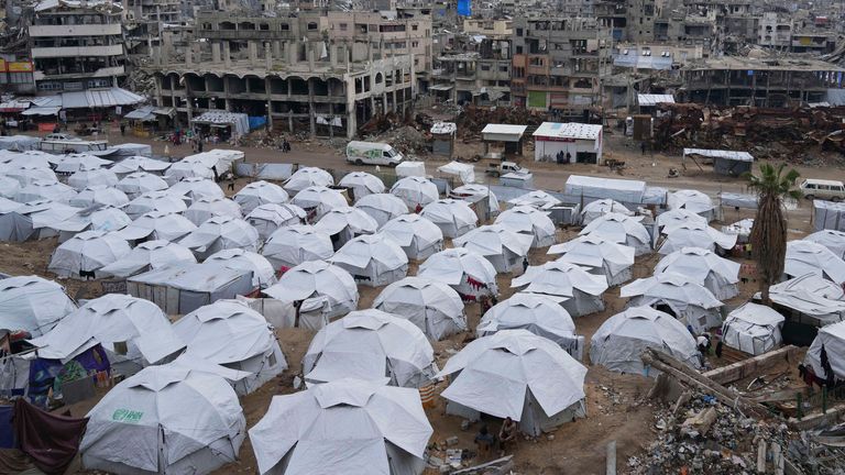 A sprawling tent camp for displaced Palestinians sits adjacent to destroyed homes and buildings in Gaza City, Gaza Strip, Saturday, March 1, 2025 during the Muslim holy month of Ramadan. (AP Photo/Abdel Kareem Hana)