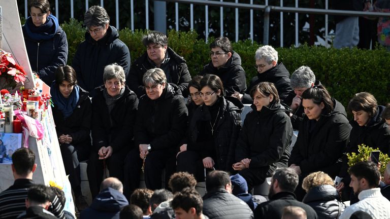 People pray for Pope Francis next to the statue of the late pope John Paul II outside Gemelli hospital. Pic: Reuters