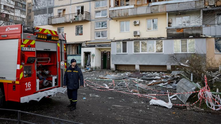 A firefighter works at a site of a building hit by a Russian drone strike in Kyiv on 23 March. Pic: Reuters 