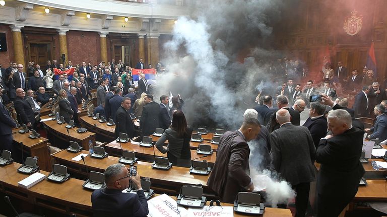 In this grab taken from video provided by RTS Serbia smoke bombs and flares are released in parliament, in Belgrade, Serbia, Tuesday, March 4, 2025. (RTS Serbia via AP)