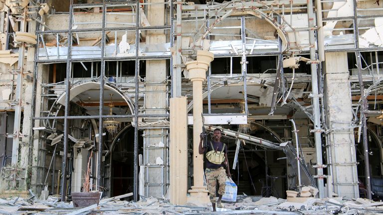 An army soldier walks in front of the damaged Republican Palace. Pic: AP