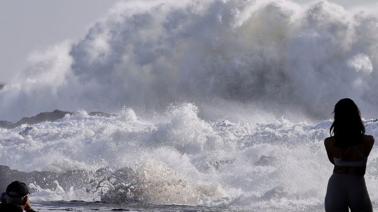 People watch as huge swells hit the beaches on the Gold Coast, Australia..
Pic: AAP/AP