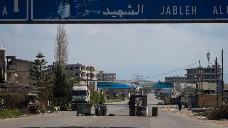 An abandoned makeshift checkpoint is seen in the middle of an empty street following the recent wave of violence between Syrian security forces and gunmen loyal to former President Bashar Assad, as well as subsequent sectarian attacks, on the outskirts of Latakia, Syria's coastal region, Monday, March 10, 2025. (AP Photo/Omar Albam)