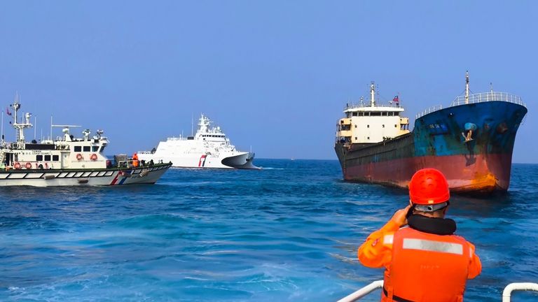 In this photo released by the Taiwan Coast Guard, Taiwanese Coast Guard vessels prepare to board Togolese-flagged cargo ship Hongtai suspected of severing an undersea communications cable in waters between its main island's west coast and the outlying Penghu islands early Tuesday, Feb 25, 2025. (Taiwan Coast Guard via AP)