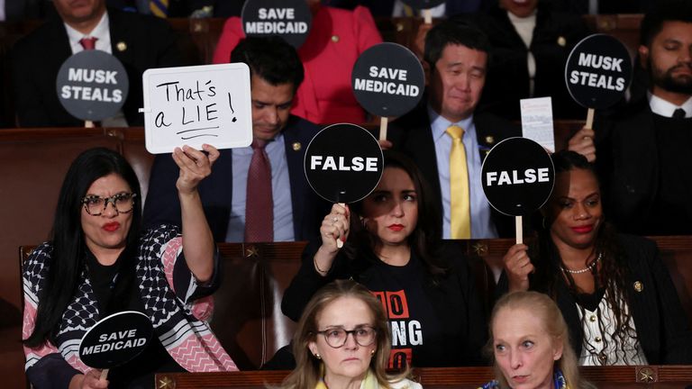 Democrats hold up placards during Trump's speech. Pic: Reuters