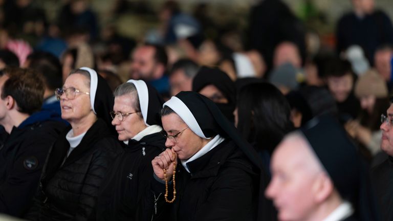 Catholic faithful attend a nightly rosary prayer for the health of Pope Francis in St. Peter's Square at the Vatican, Sunday, March 2, 2025. (AP Photo/Mosa'ab Elshamy)