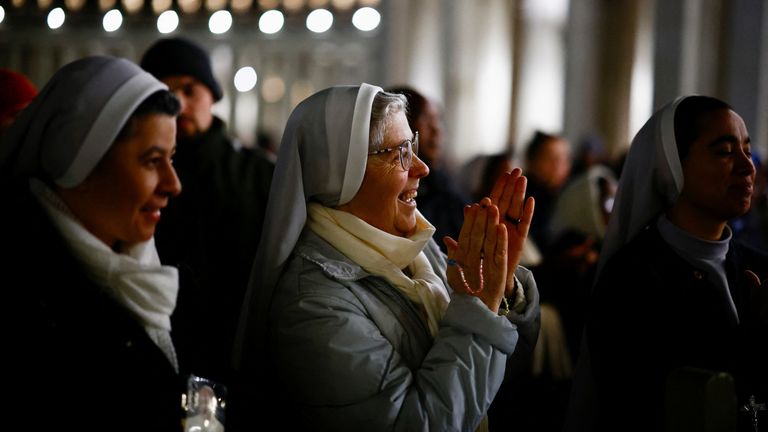 Faithful listen to an audio message by Pope Francis at the Vatican, March 6, 2025. REUTERS/Yara Nardi