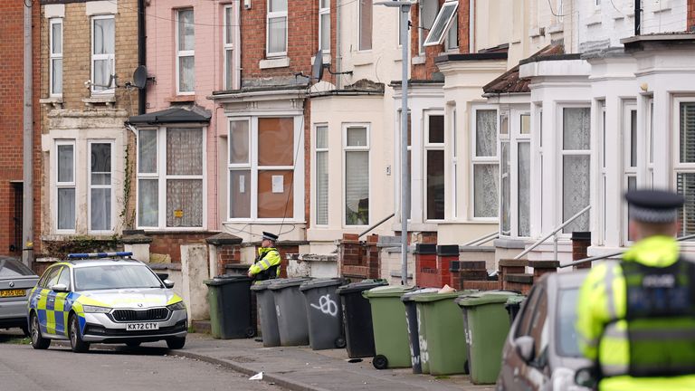 Police officers outside the house in in Wellingborough's Newcomen Road that was damaged by fire.  Pic: PA