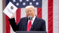 Donald Trump holds a ''Foreign Trade Barriers'' document as he delivers remarks on tariffs in the Rose Garden at the White House in Washington.
Pic: Reuters
