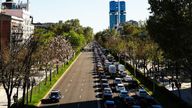A police car passes as vehicles wait in a traffic jam on the other side of the road in Madrid. Pic: Reuters