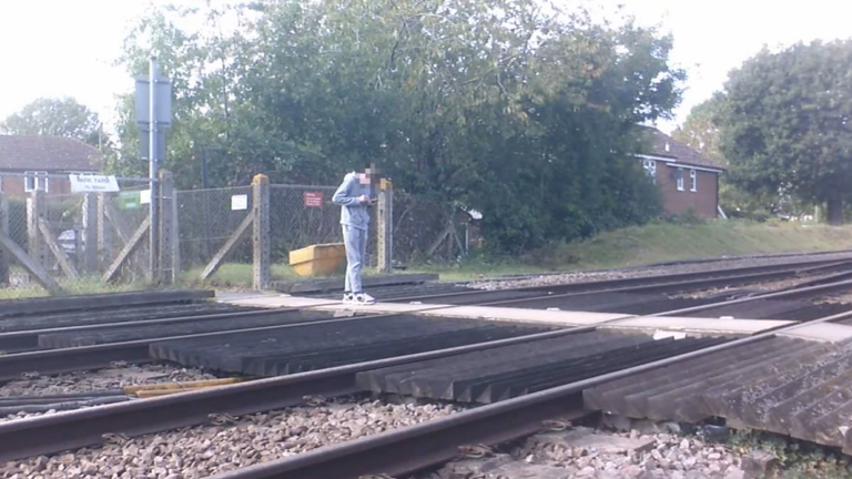 Materiał filmowy pokazuje, że nastolatek stał na środku przejścia kolejowego, wpatrując się w jego telefon. Zdjęcie: National Rail