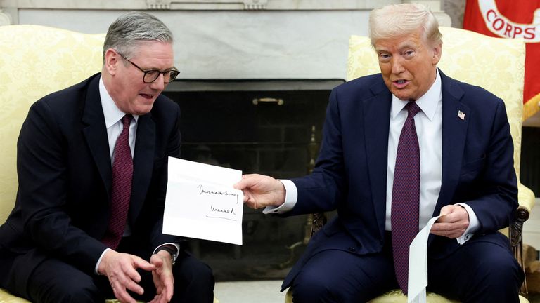 U.S. President Donald Trump holds a letter from Britain's King Charles as he meets with British Prime Minister Keir Starmer in the Oval Office at the White House in Washington, D.C., U.S., February 27, 2025. REUTERS/Kevin Lamarque TPX IMAGES OF THE DAY