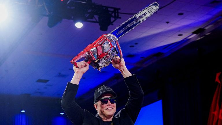 FILE PHOTO: Elon Musk holds a chainsaw onstage as he attends the Conservative Political Action Conference (CPAC) in National Harbor, Maryland, U.S., February 20, 2025. REUTERS/Nathan Howard     TPX IMAGES OF THE DAY/File Photo
