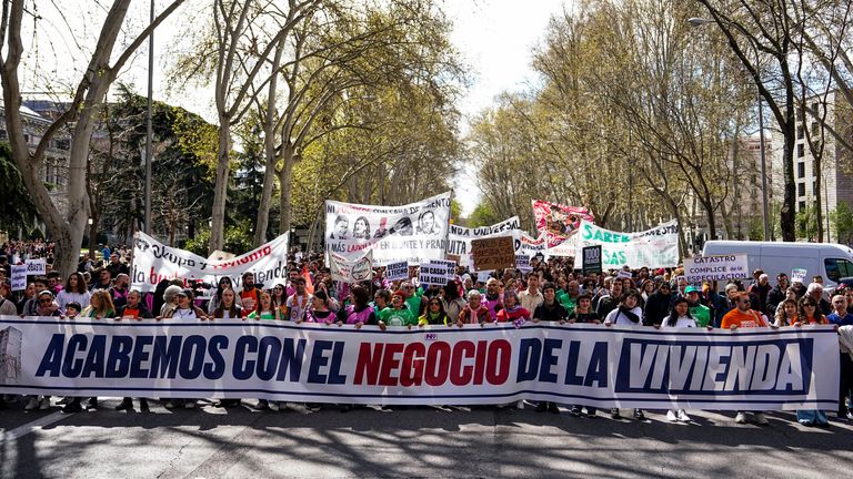 People in Madrid carrying a banner which reads: 'We are done with the housing business'. Pic: Reuters