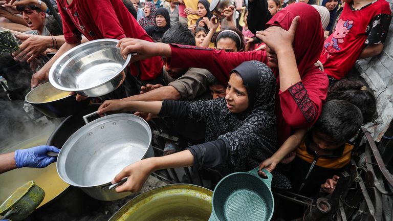 Palestinians in Gaza receive food from a charity kitchen.
Pic: Reuters/Mahmoud Issa