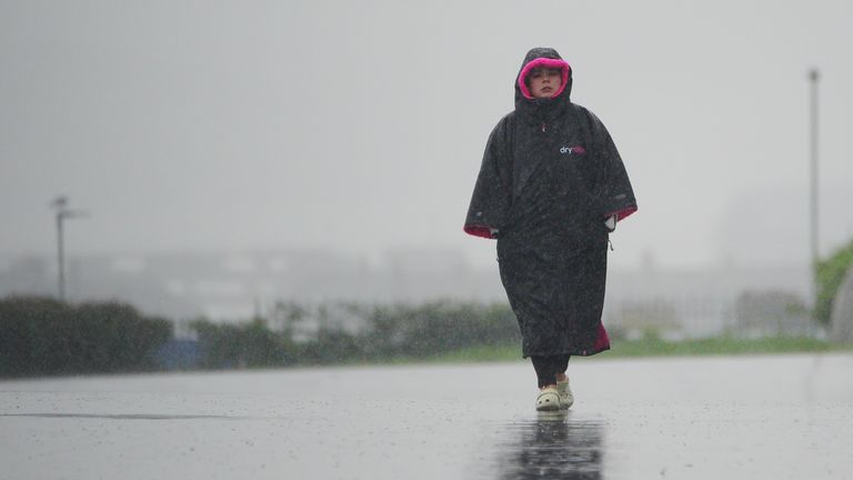 A woman braves the heavy rain at Plymouth Hoe. 
Pic: PA