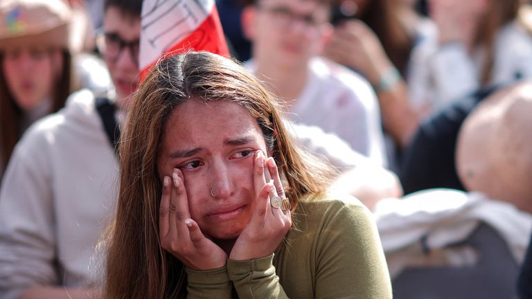 A woman cries as crowds watch the late pontiff's body being moved. Pic: Reuters